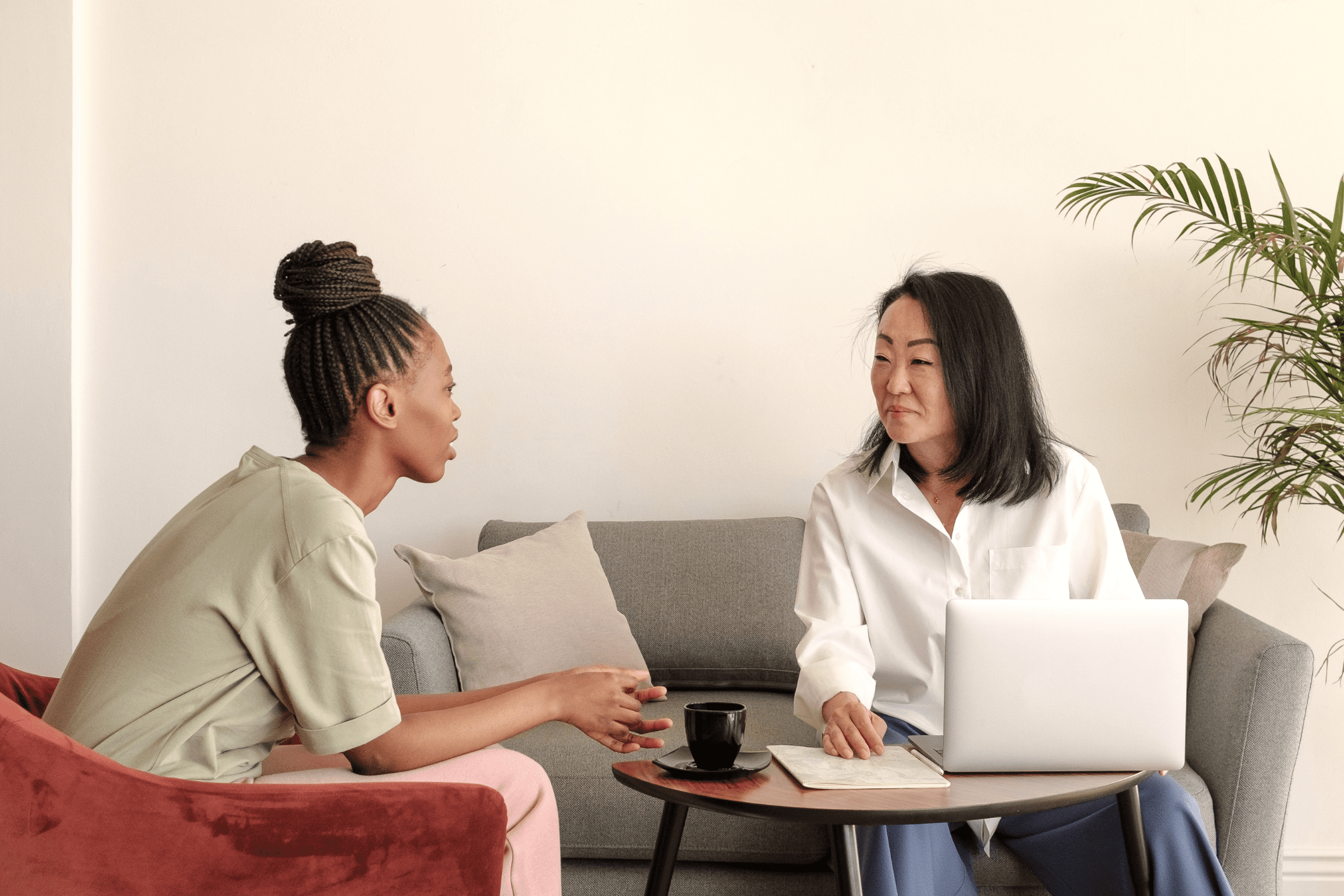 Therapist and client sitting in a calm office setting, having a supportive conversation during a therapy session