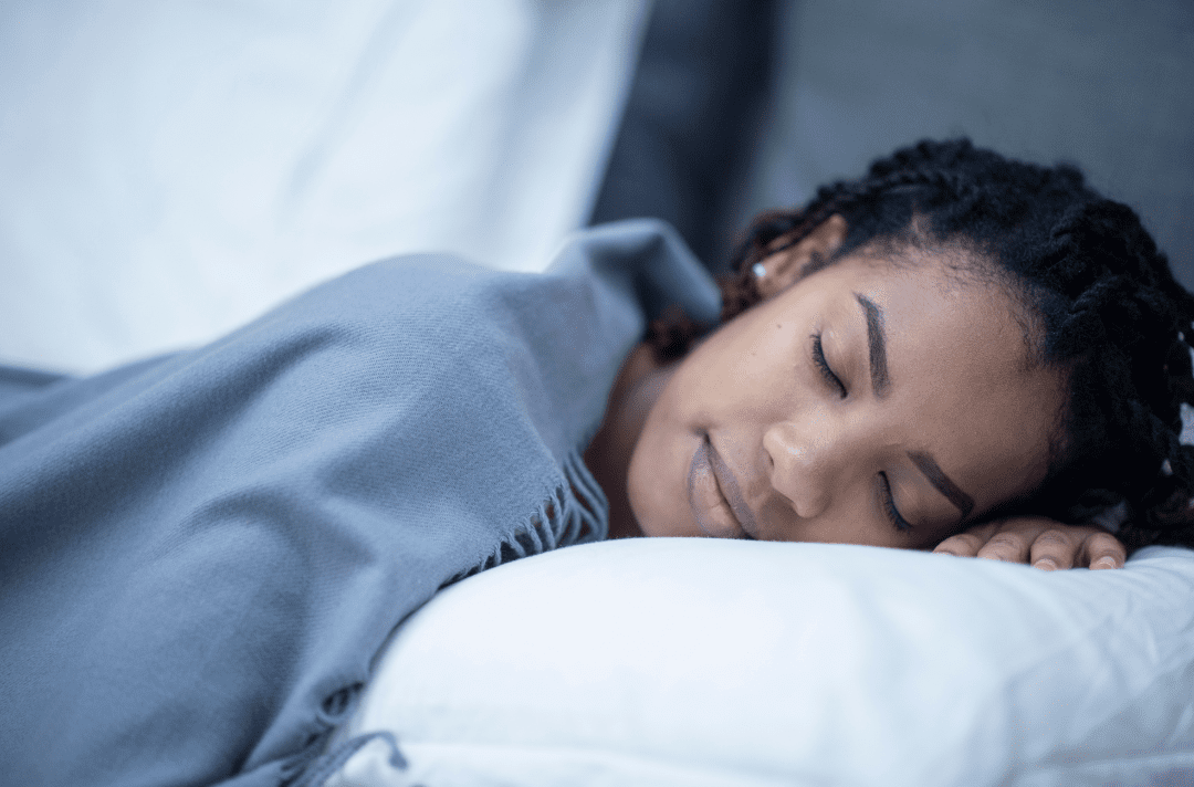 dayrise center picture 3 - Dayrise Wellness Person resting peacefully on a bed with a soft gray blanket, eyes closed in sleep
