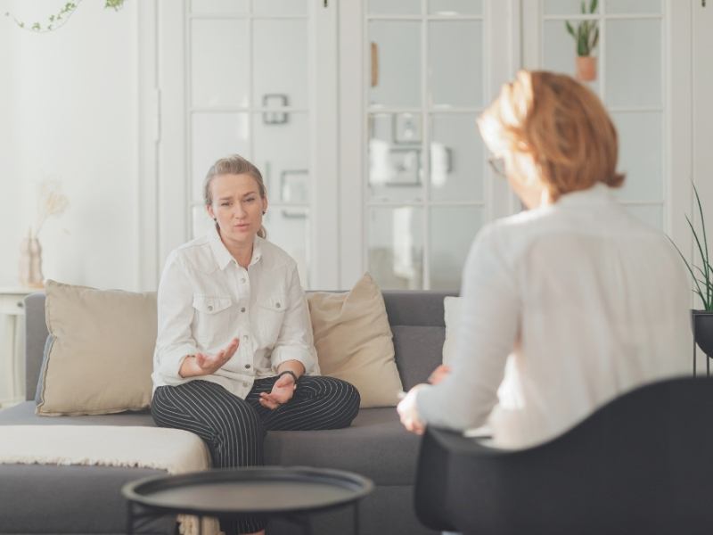 Dayrise Blog Images - Dayrise Wellness Woman speaking openly with a therapist during a trauma therapy session in a calm, welcoming office setting