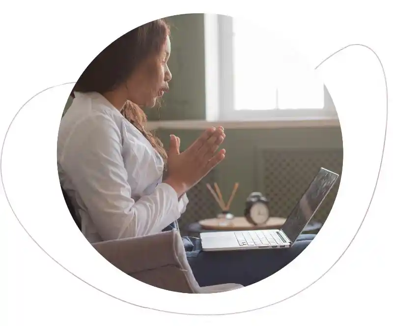 a woman signs on her laptop to participate in online mental health therapy